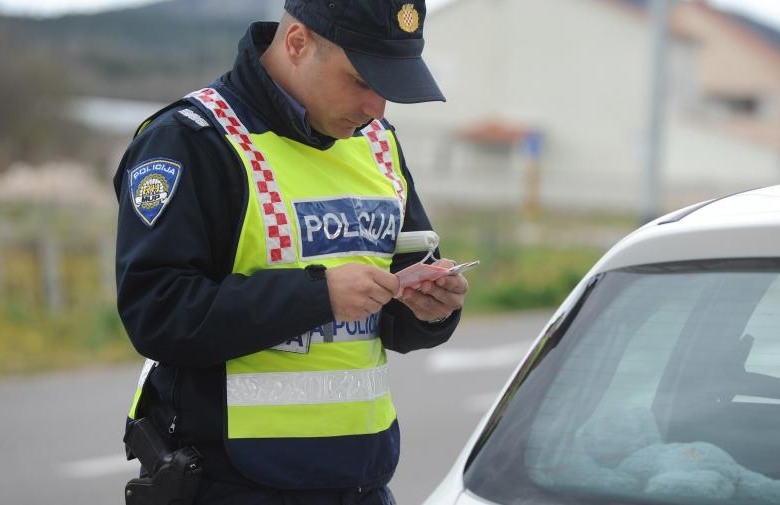 9528.policajac gleda prometne dokumente